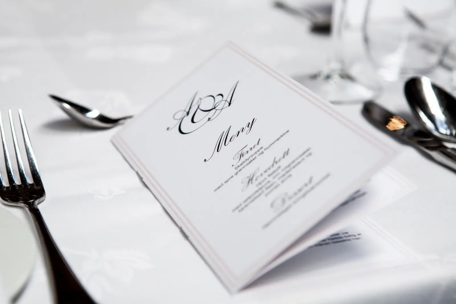 A printed menu arranged on a formal dining table