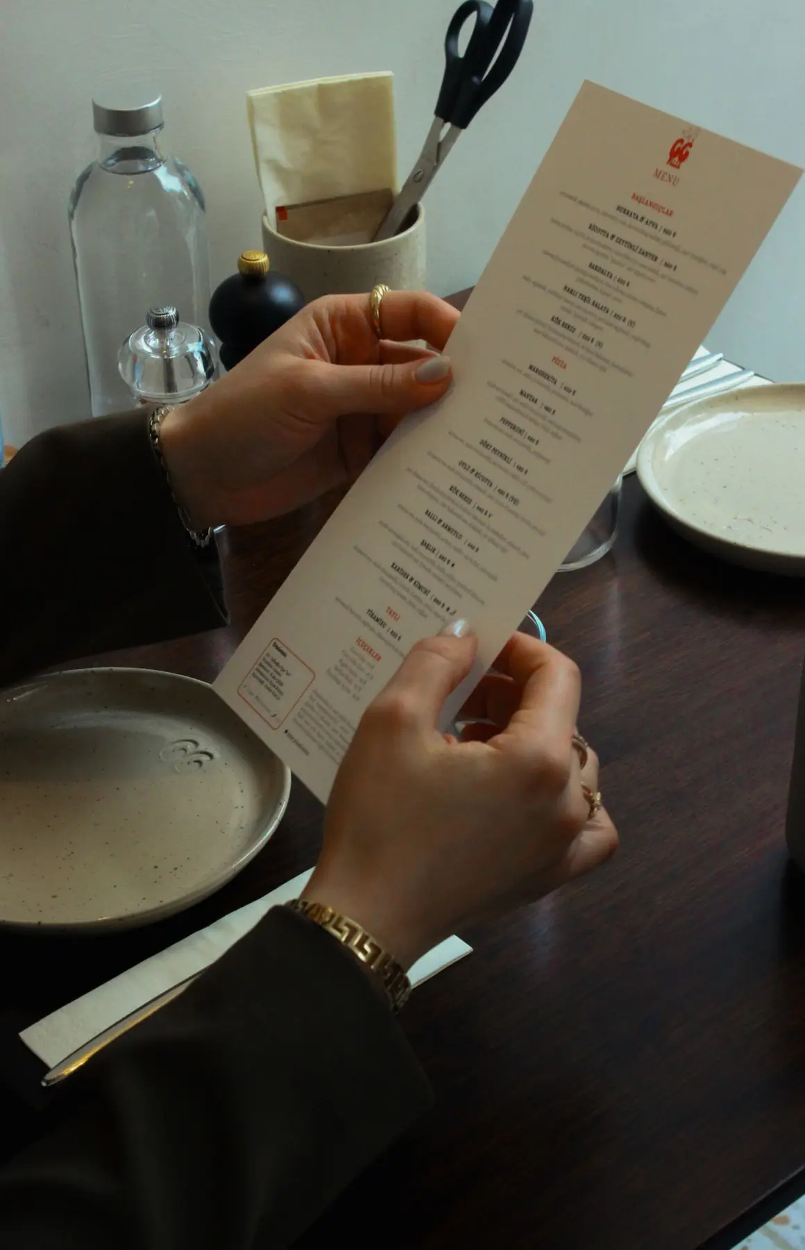 A restaurant guest reading a printed menu at a table